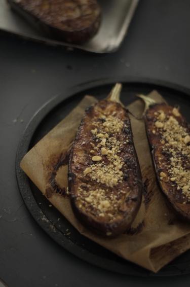 Close up of two halves of a roasted aubergine on a round metal tray
