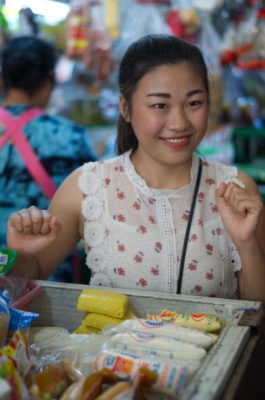Woman smiling at an Asian wet market as she takes questions for visitors