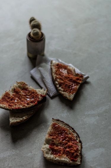 Three slices of Maltese bread with a tomato paste spread 