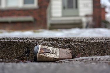 A dirty disposable coffee cup left on the street