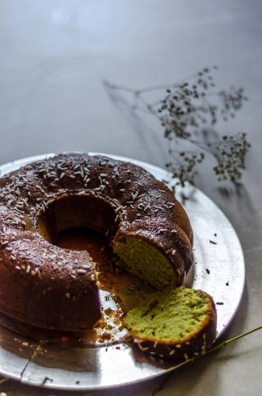 Sliced bundt cake on a silver tray surrounded by dried flowers