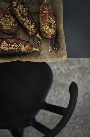 Top view of a tray of roasted aubergines and a chair