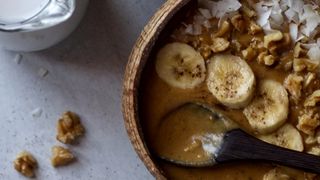 Top down view of smoothie bowls and a jug of coconut milk