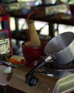 An outdoor cooking school with pots and portable stoves lined up