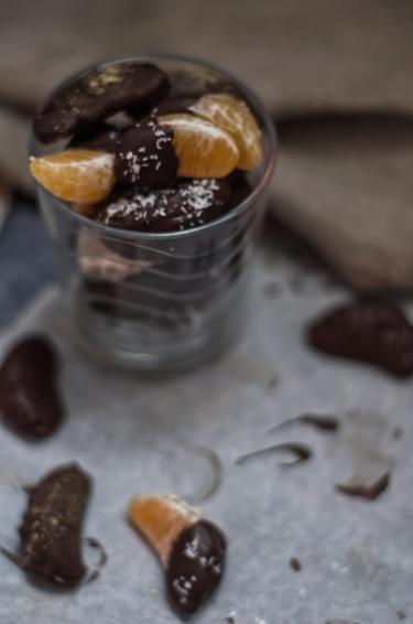 Chocolate coated clementine segments stacked in a glass 