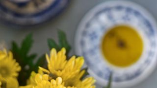 Overhead shot of turmeric milk in a bone china tea cup and saucer