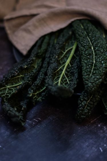 Kale bunched up with a cloth of linen covering part of them