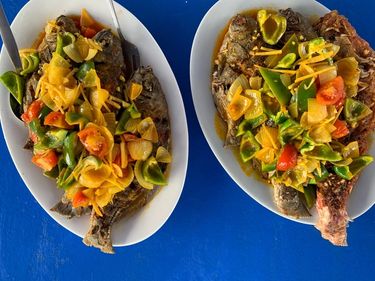 Fried whole fish dressed with pan fried vegetables