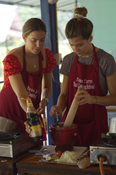 Two friends cooking together at a cooking school