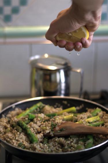 Pan with buckwheat and asparagus being cooked on a stove