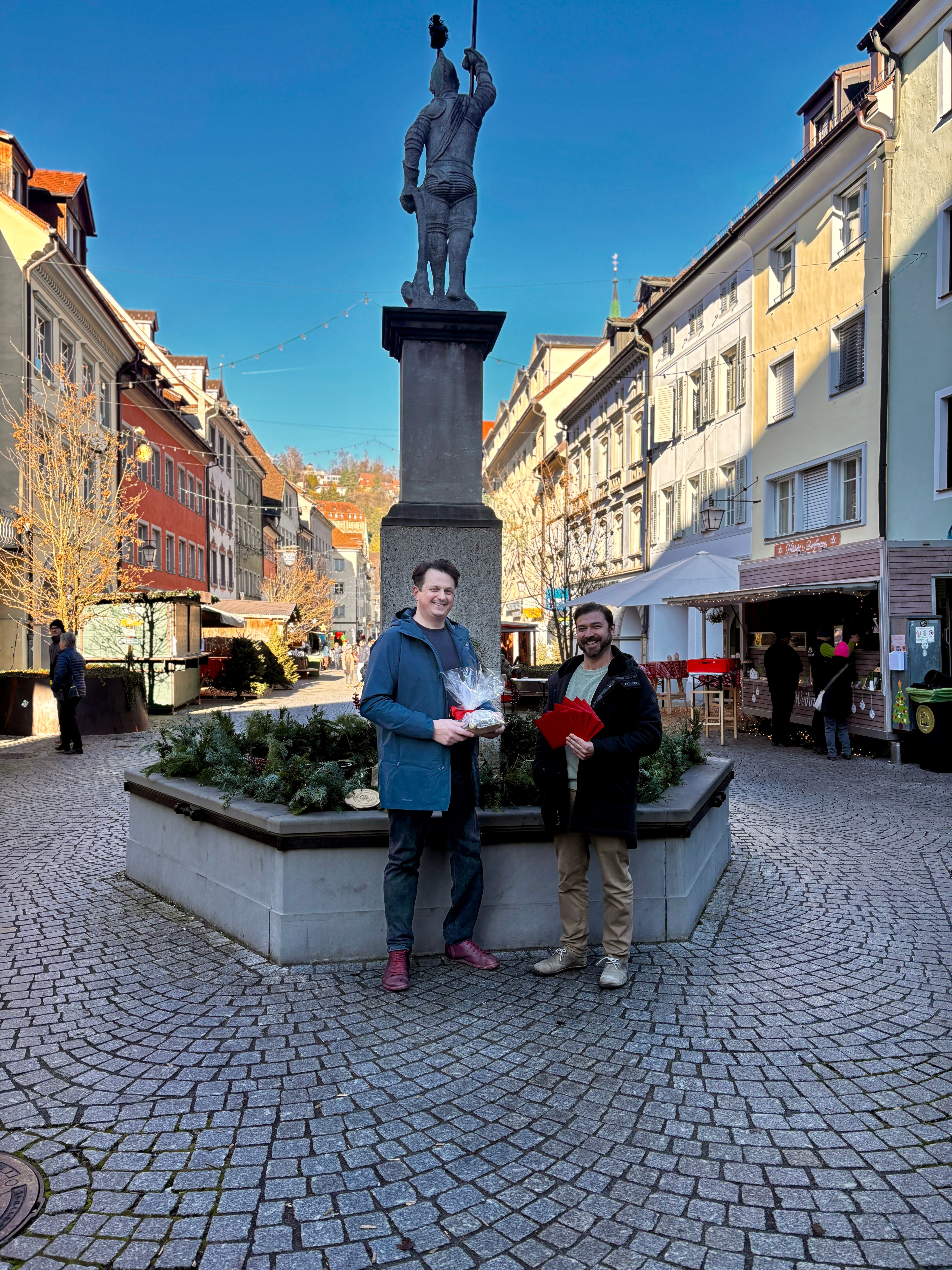 Oliver übergibt Marc Fleisch von pro mente v die Einkaufsgutscheine für die Familien