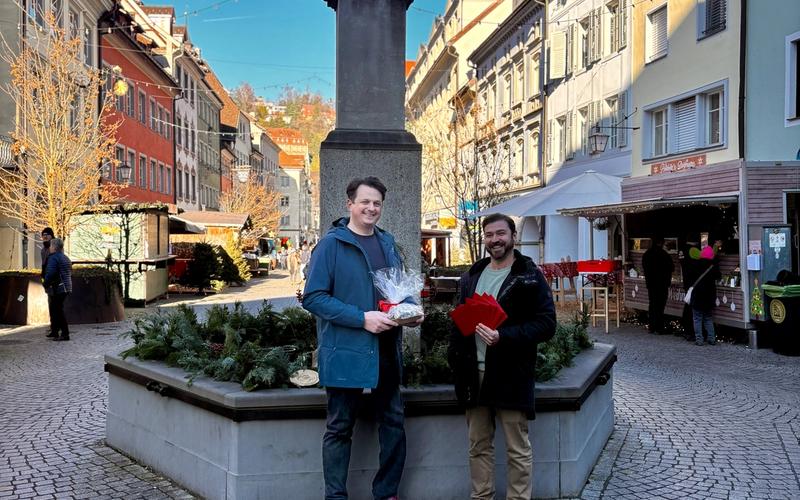 Oliver übergibt Marc Fleisch von pro mente v die Einkaufsgutscheine für die Familien