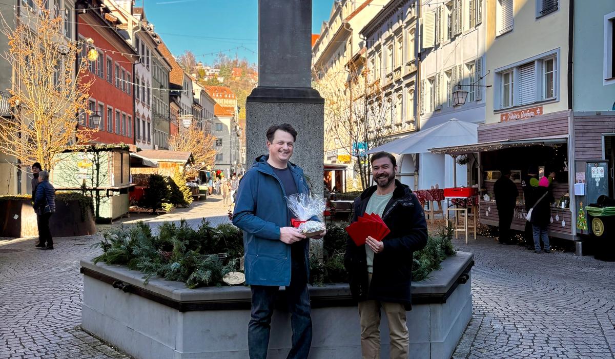 Oliver übergibt Marc Fleisch von pro mente v die Einkaufsgutscheine für die Familien