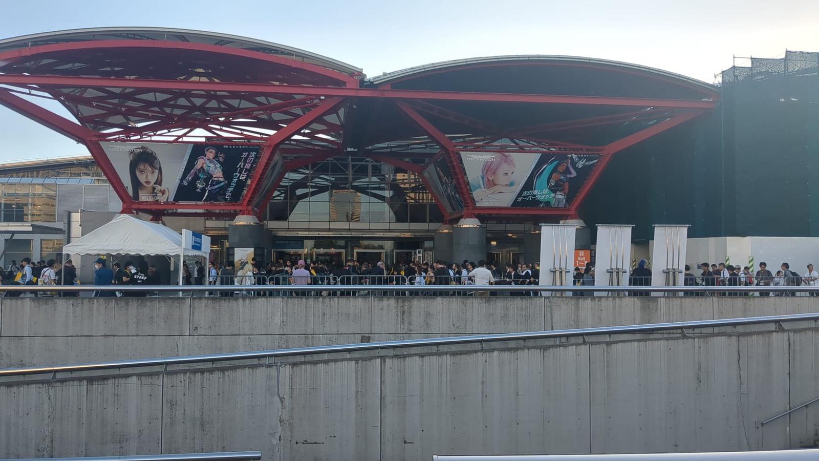 Entrén till Makuhari Messe med rött välvt tak, banderoller för Tokyo Game Show och besökare i kö.