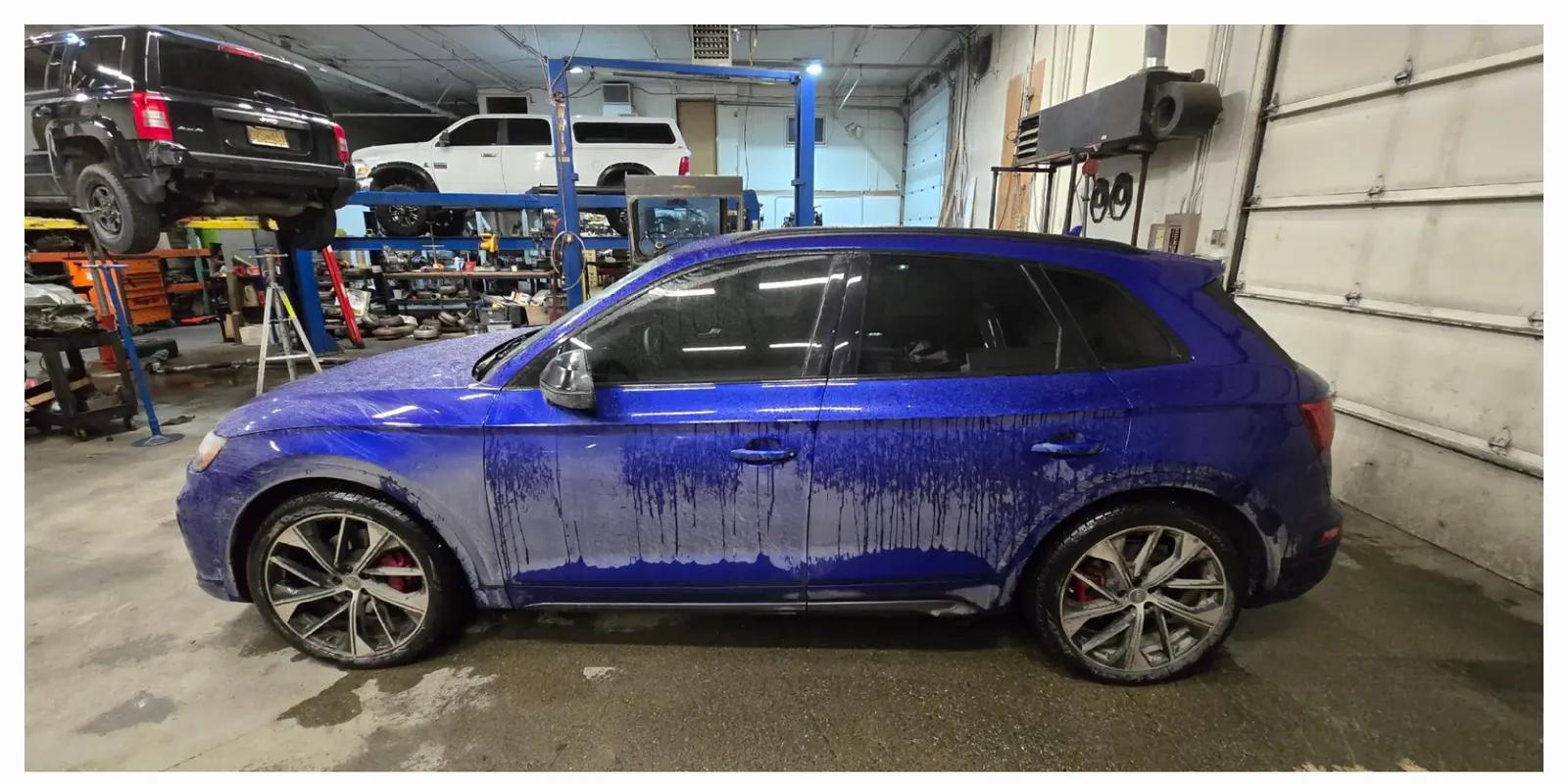 Blue Audi SQ5 covered in foam during exterior decontamination in Anchorage, Alaska