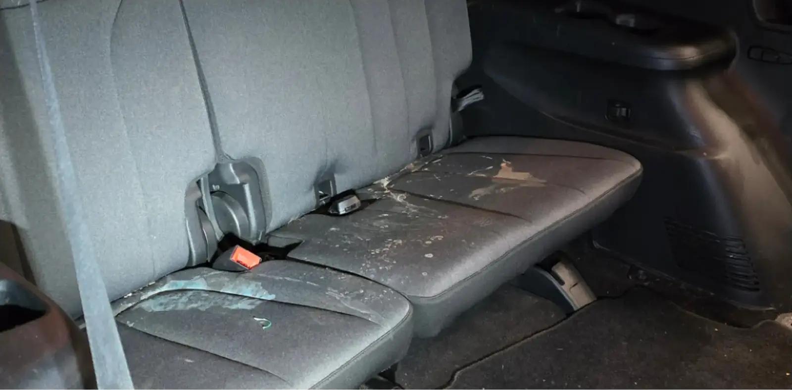 Minivan rear bench cloth seats stained with spills before stain removal in Anchorage, Alaska