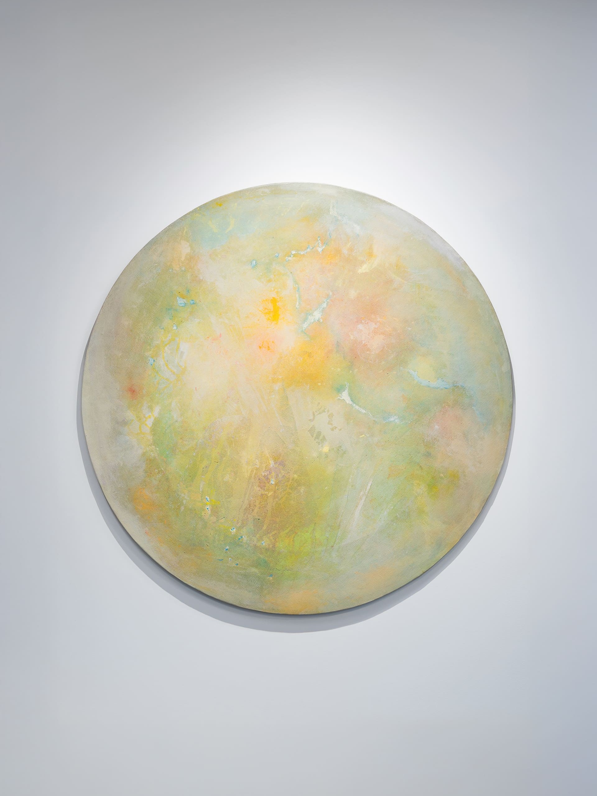 An abstract painting with a mix of dark and muted colors, featuring overlapping black and yellow lines that create a web-like or structural pattern. The background blends tones of gray, brown, and green, giving a sense of depth and texture. The brushstrokes are soft and blurred, suggesting motion or atmosphere rather than clear forms. The painting is framed in a simple wooden frame and mounted on a white wall, with the artist’s signature faintly visible in the bottom left corner.