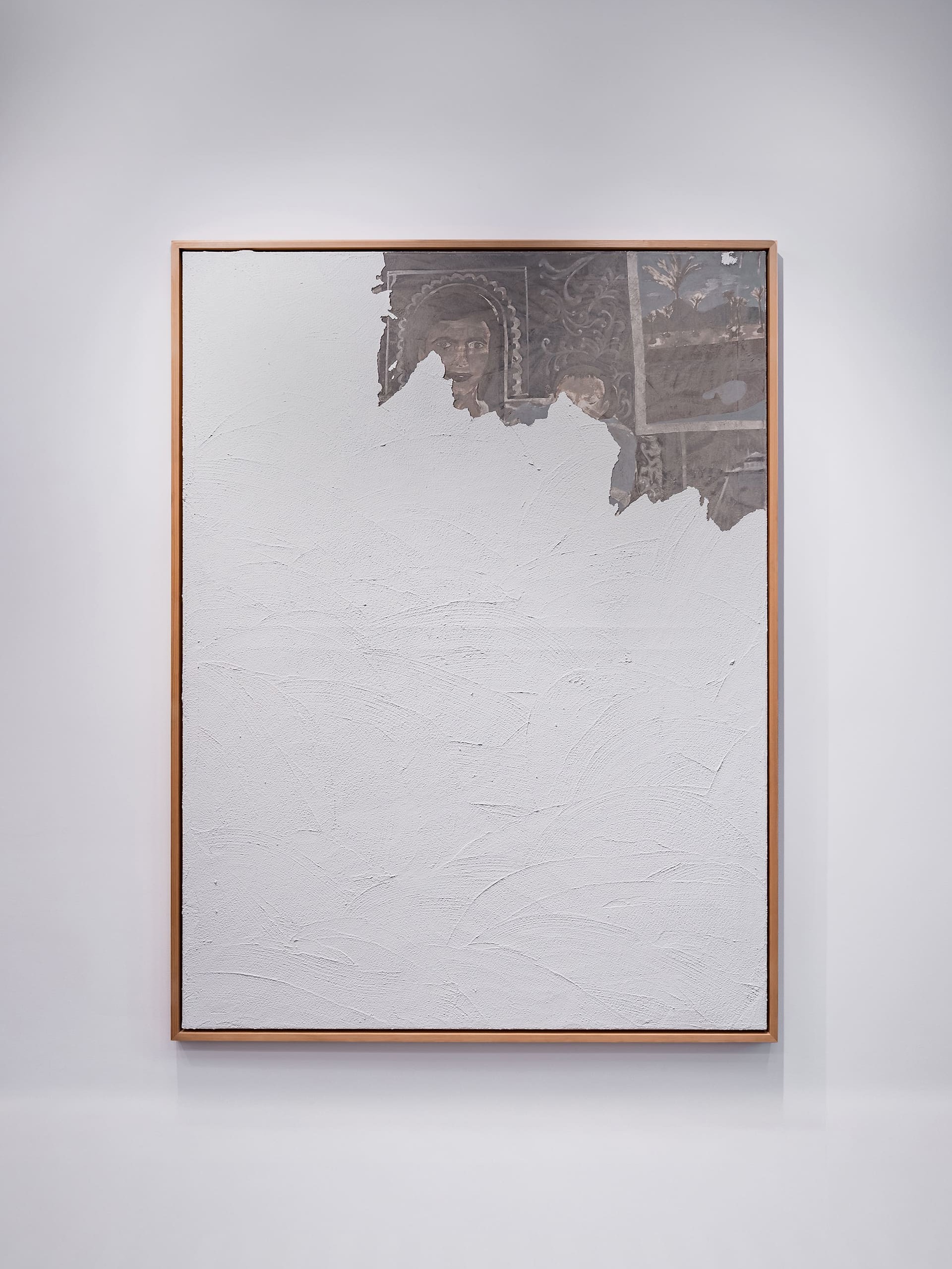 Large framed painting with a predominantly textured white surface. Along the top, torn-looking areas reveal an underlayer in muted browns, grays, and sepia tones, showing partially visible human faces and ornate decorative patterns, as if fragments of an aged mural are emerging through the white expanse.