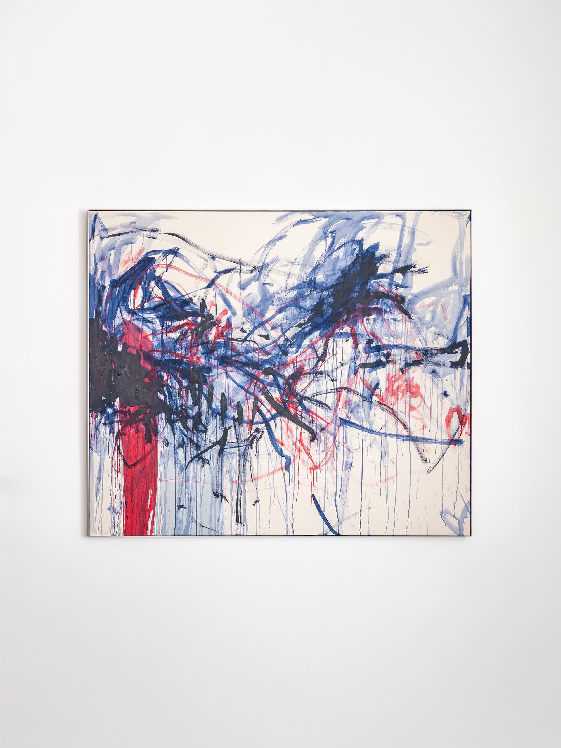Abstract painting featuring expressive brushstrokes in deep blue, navy, black, bright red, magenta, and pale pink on a light cream background. Broad sweeping lines, drips, and layered marks overlap to form a chaotic, dynamic composition, with darker tones concentrated on the left and more dispersed strokes extending toward the right.”