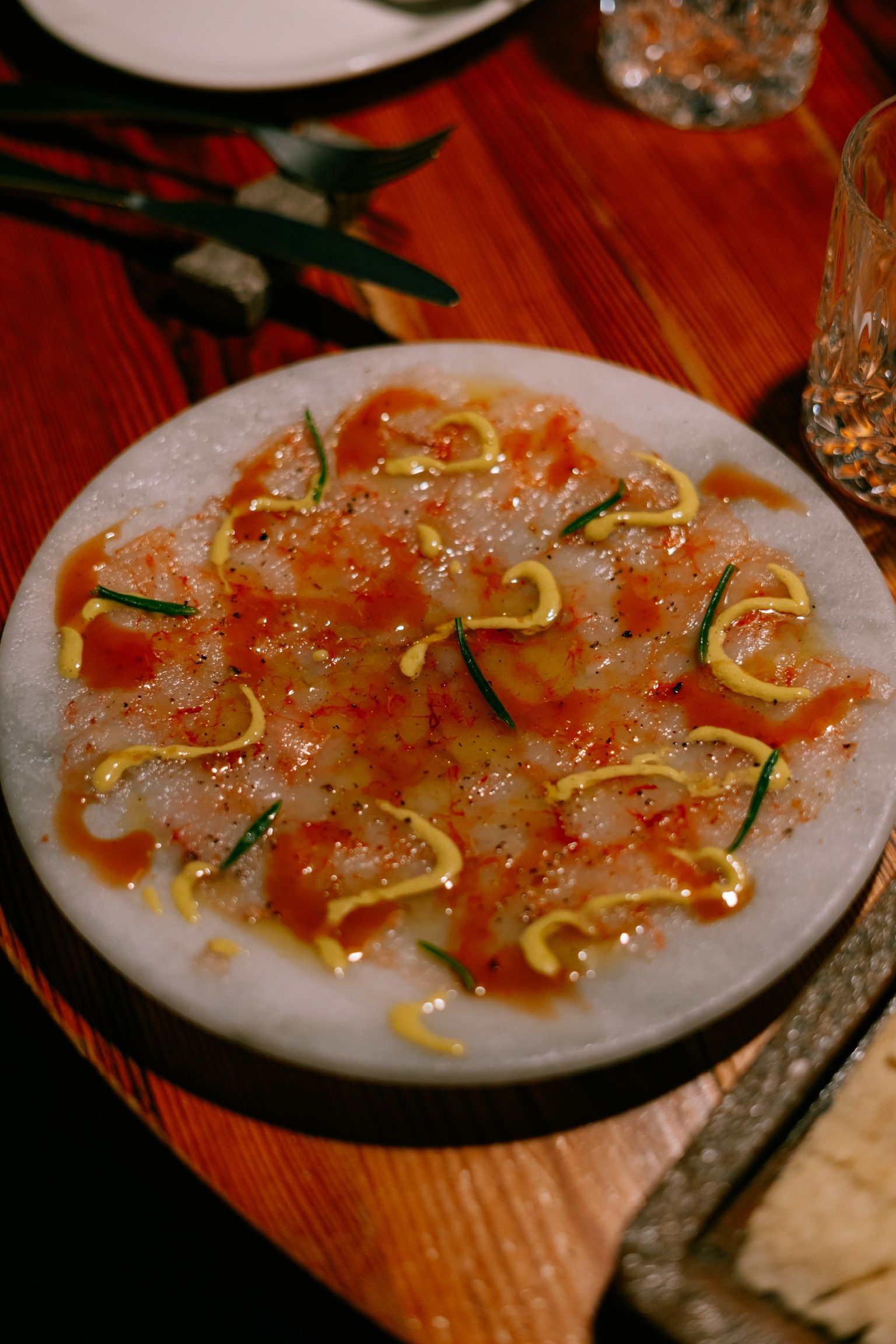 Carpaccio de gamba roja con mayonesa en un plato de mármol