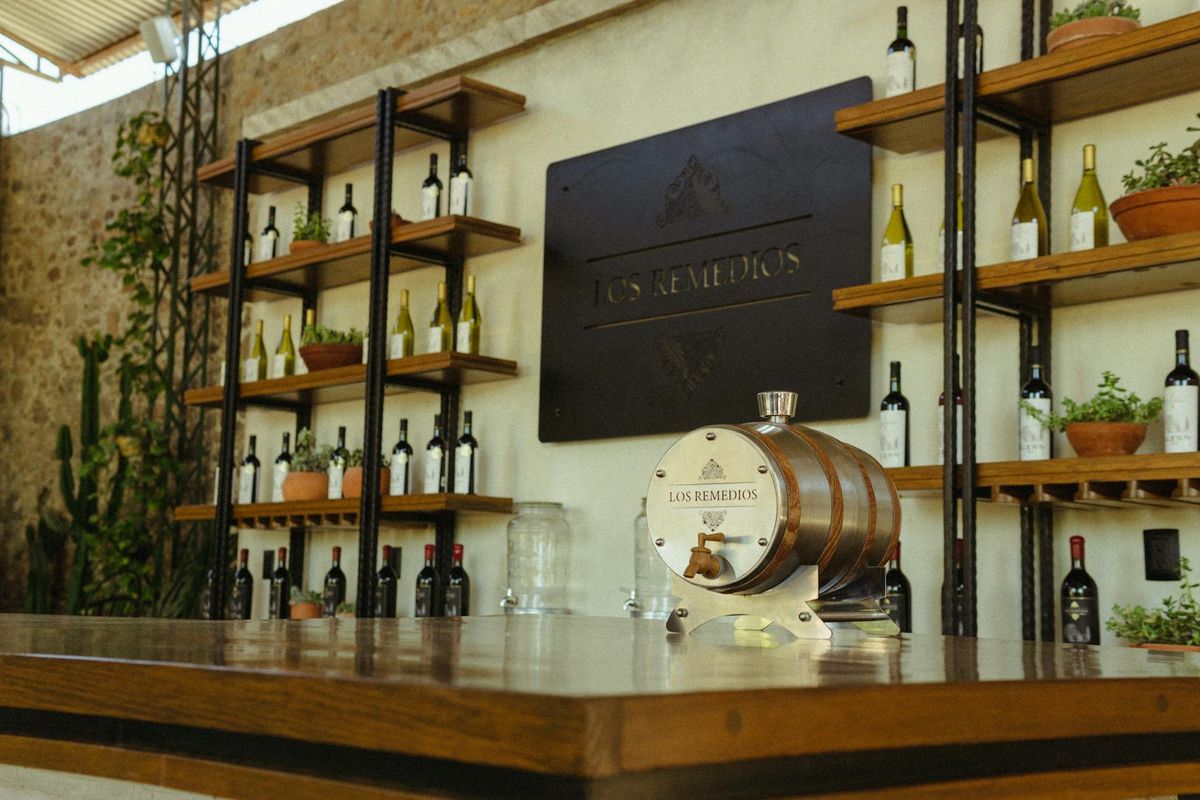 An elegant wine bar interior featuring a decorative barrel and neatly arranged wine bottles on shelves.