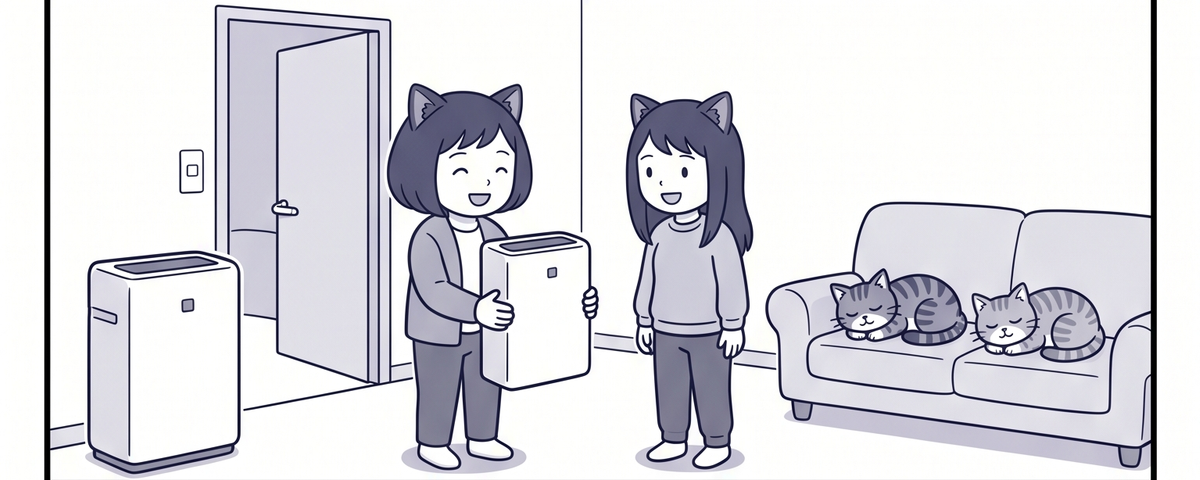 リビングに空気清浄機が2台。ママが1台を持って姉に見せ、ソファで猫2匹が寝ている