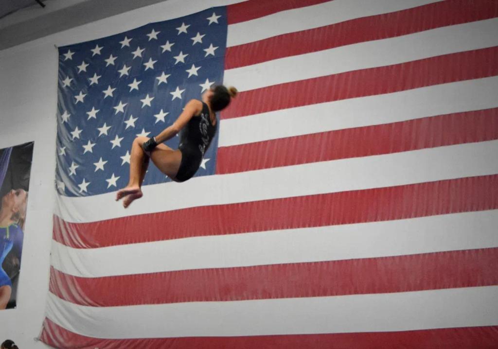 Advanced tumbler executing an aerial skill on the floor