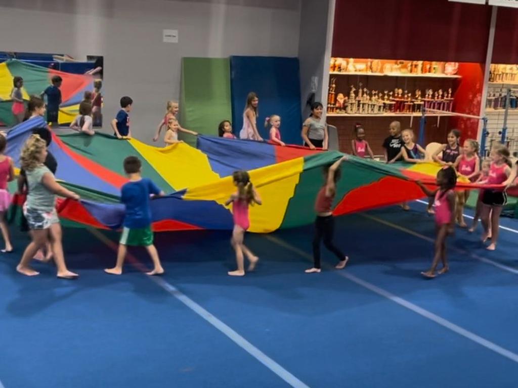 Parachute games on the gym floor at a Go For It USA birthday party