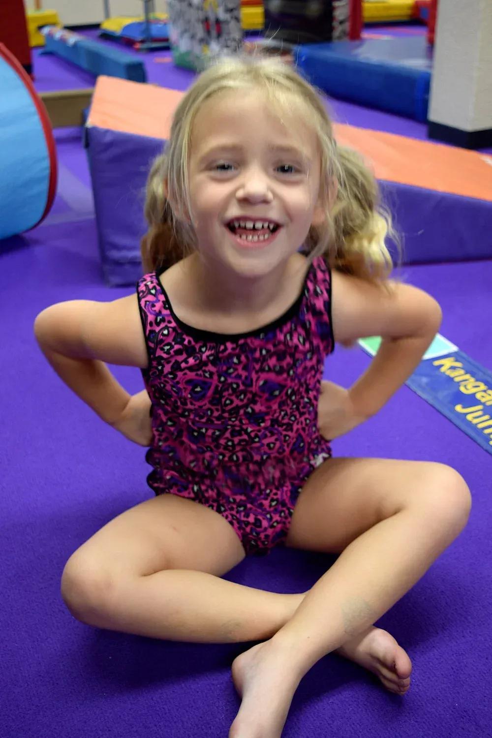 Preschool gymnast balancing on a beam during a Super Tot class