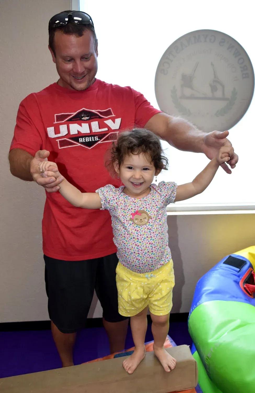 Toddler and parent moving through a Mini Stars gymnastics station together