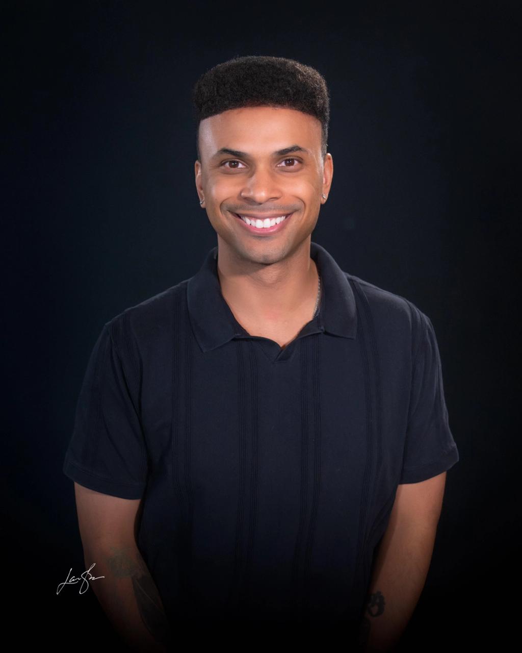 Head Coach Kyle Khou smiling against a black backdrop