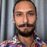 a man with a beard and mustache is wearing a colorful shirt