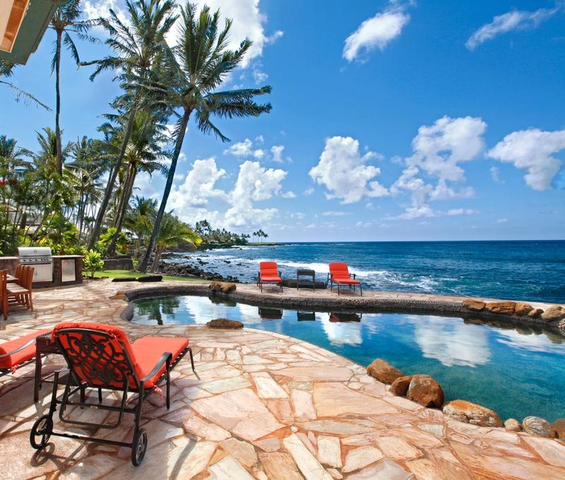 Lounge furniture with oceanfront pool at Kauai vacation rental home