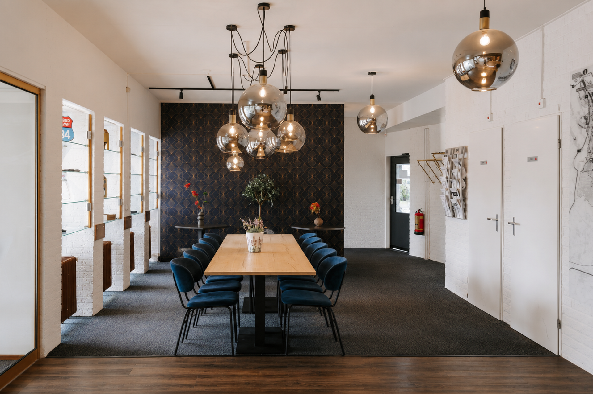Stijlvolle lobby van Hotel de Oringer Marke in Odoorn met designverlichting, lange tafel en blauwe stoelen