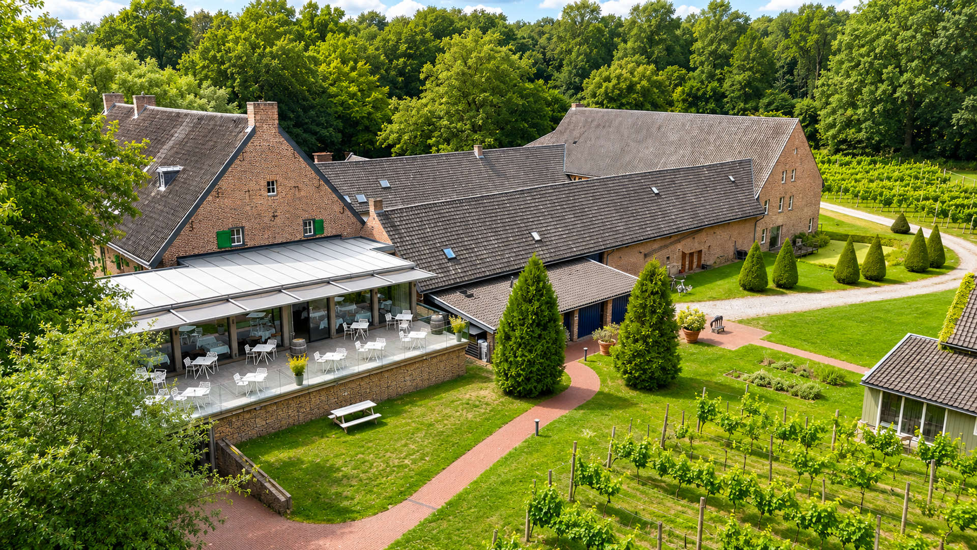 Luchtfoto van Landgoed Winselerhof in Zuid-Limburg met monumentaal hotel, eigen wijngaard en bosrijke omgeving