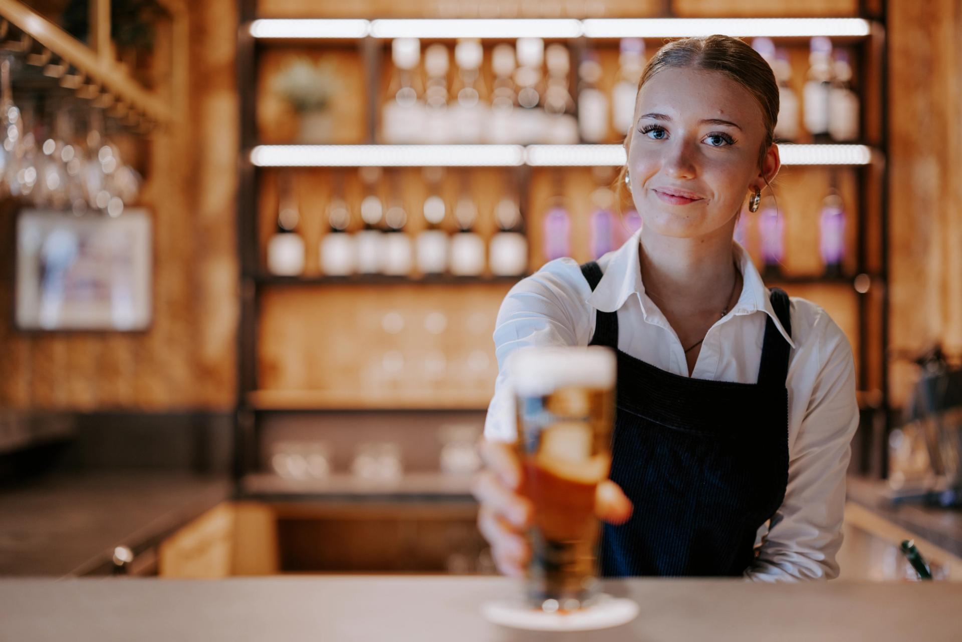 Servicemitarbeiter reicht ein Bier