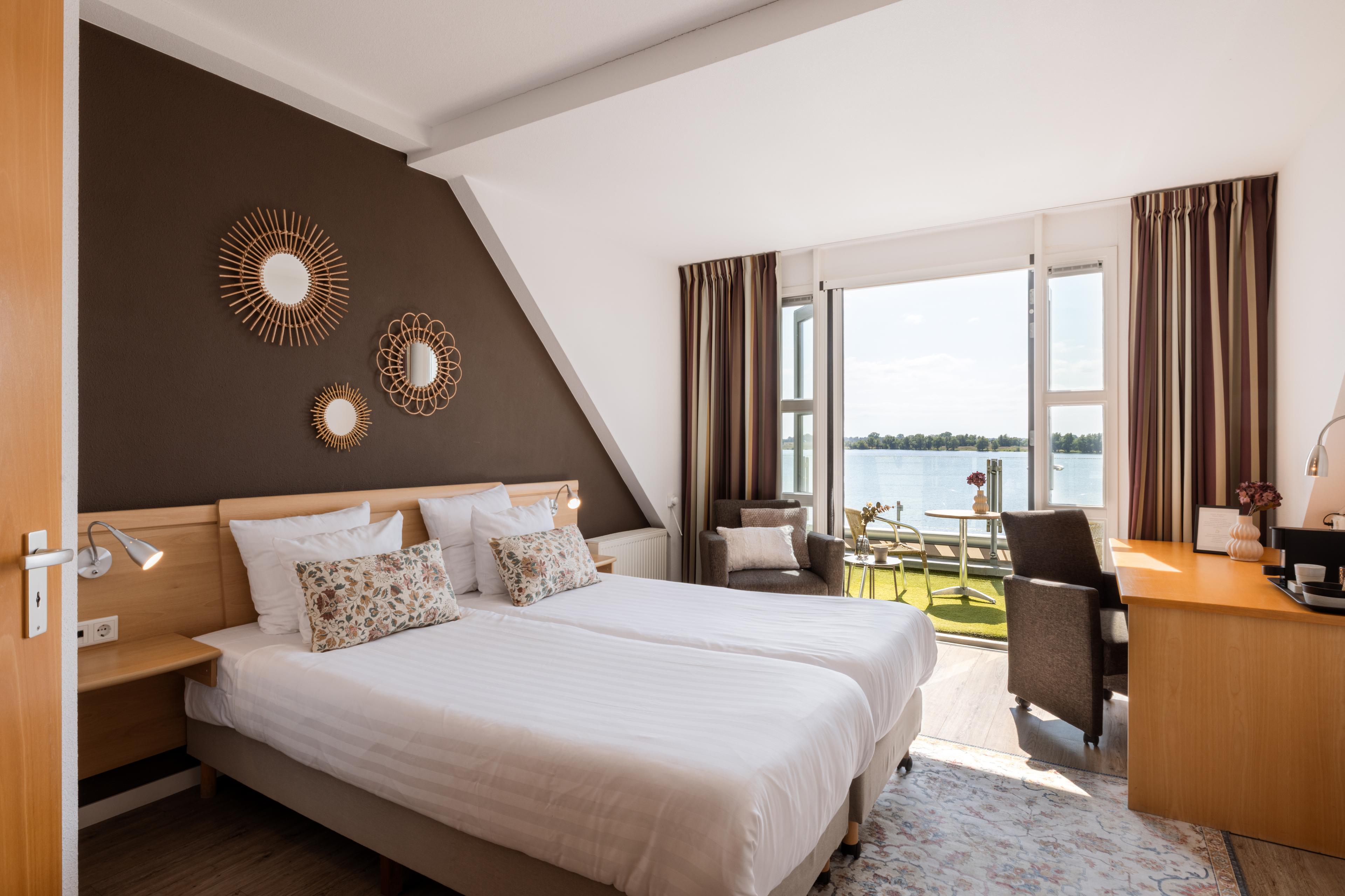 Ruime kamer met Maaszicht en balkon in Hotel Hoogeerd