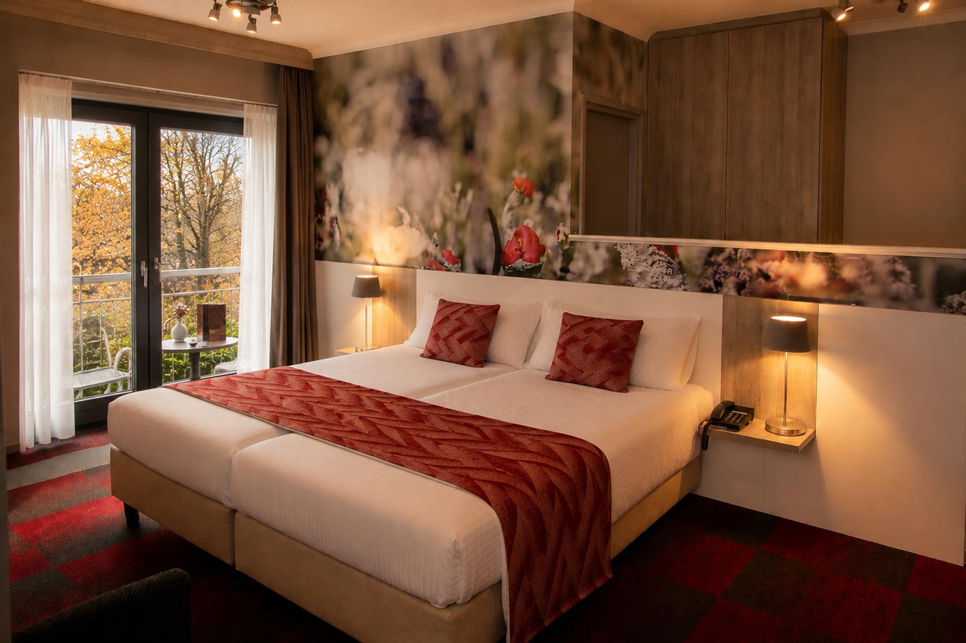 Hotelkamer met tweepersoonsbed en uitzicht op het groen bij Hotel Hof van Gelre in Lochem, Achterhoek