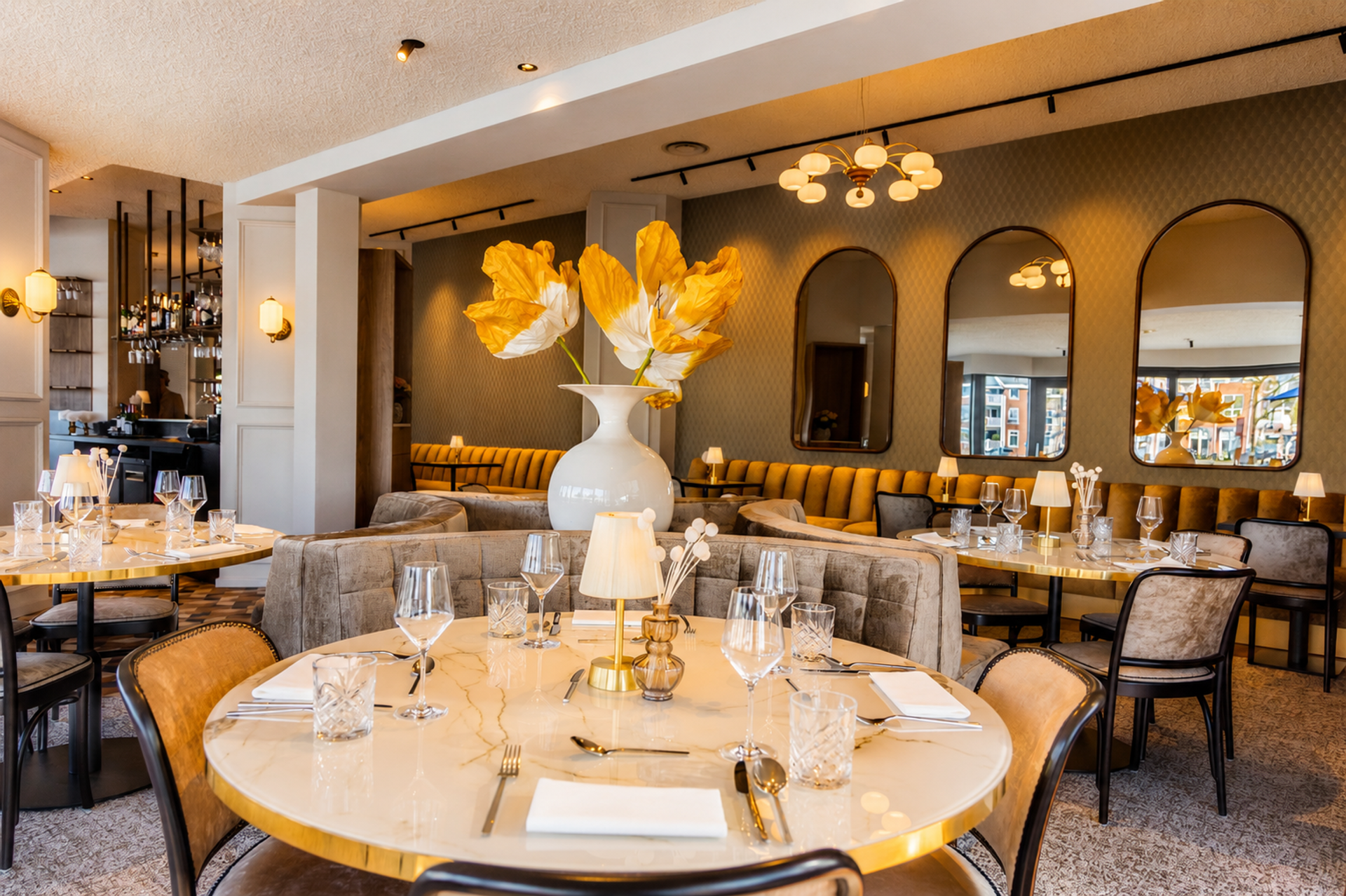 Stijlvol interieur van Brasserie Bresson bij Hotel de Zon in Ommen met marmeren tafels, gouden accenten en grote witte vaas