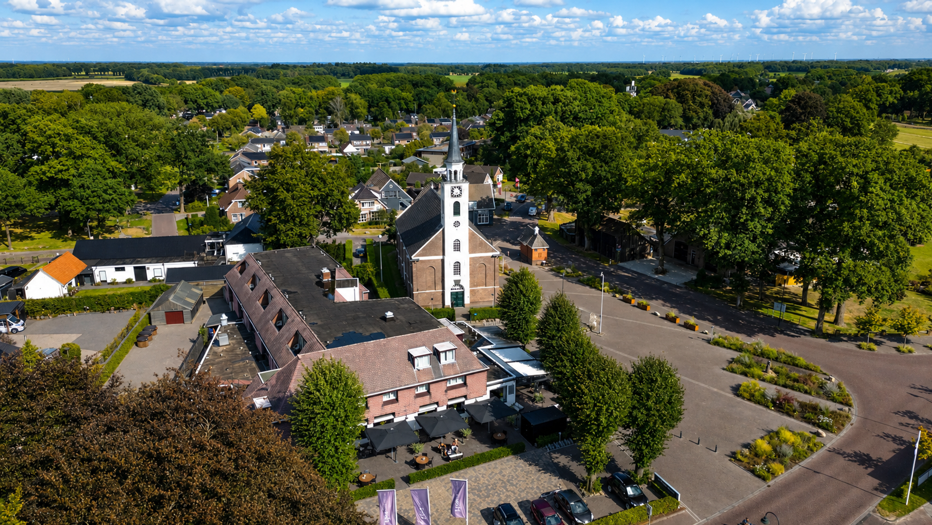 Luchtfoto van Hotel de Oringer Marke met het dorpsplein, de kerk en het terras in Odoorn