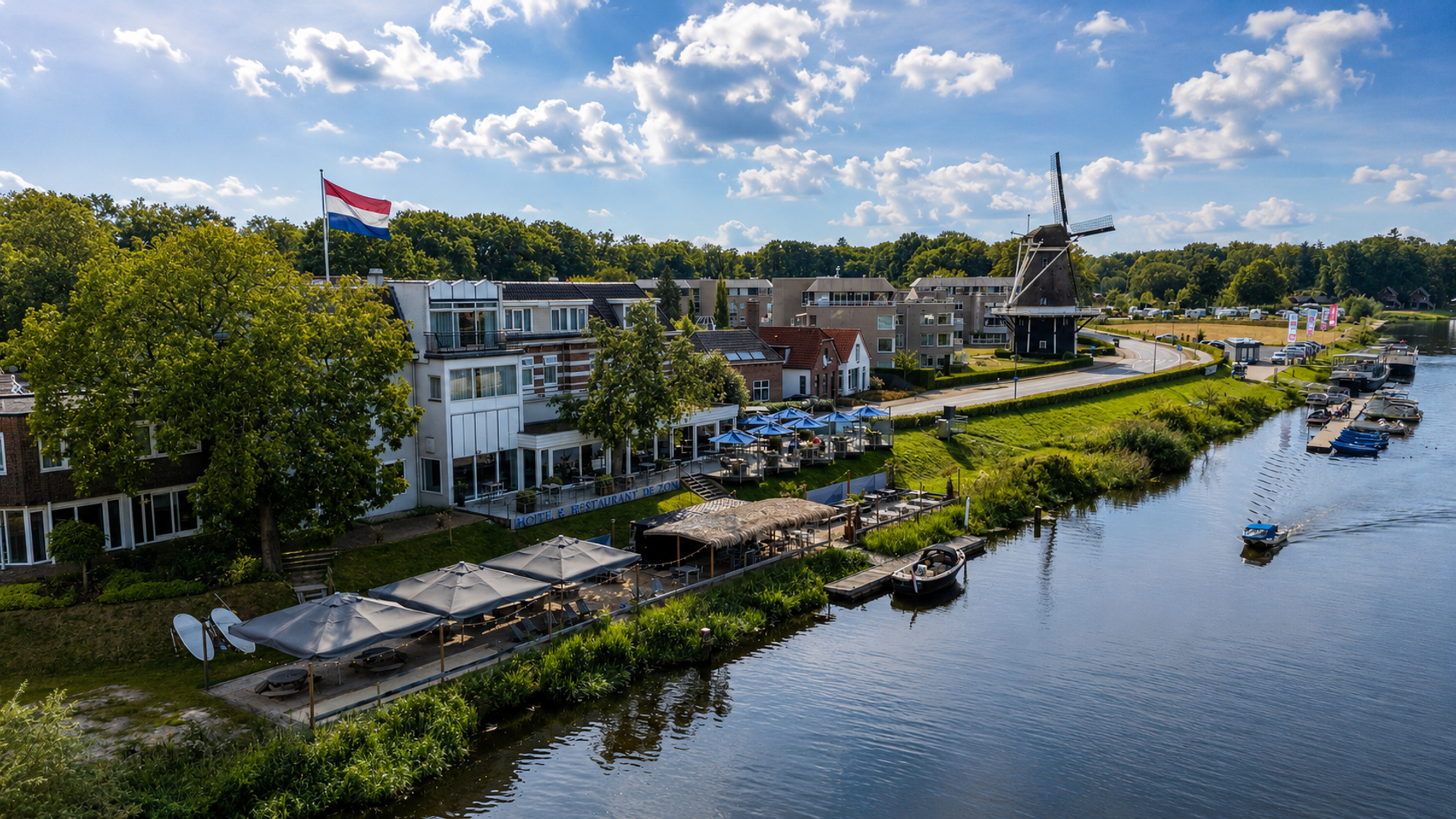 Hotel De Zon & Brasserie Bresson aan de Vecht in Ommen met terras, strandbar en molen op de achtergrond