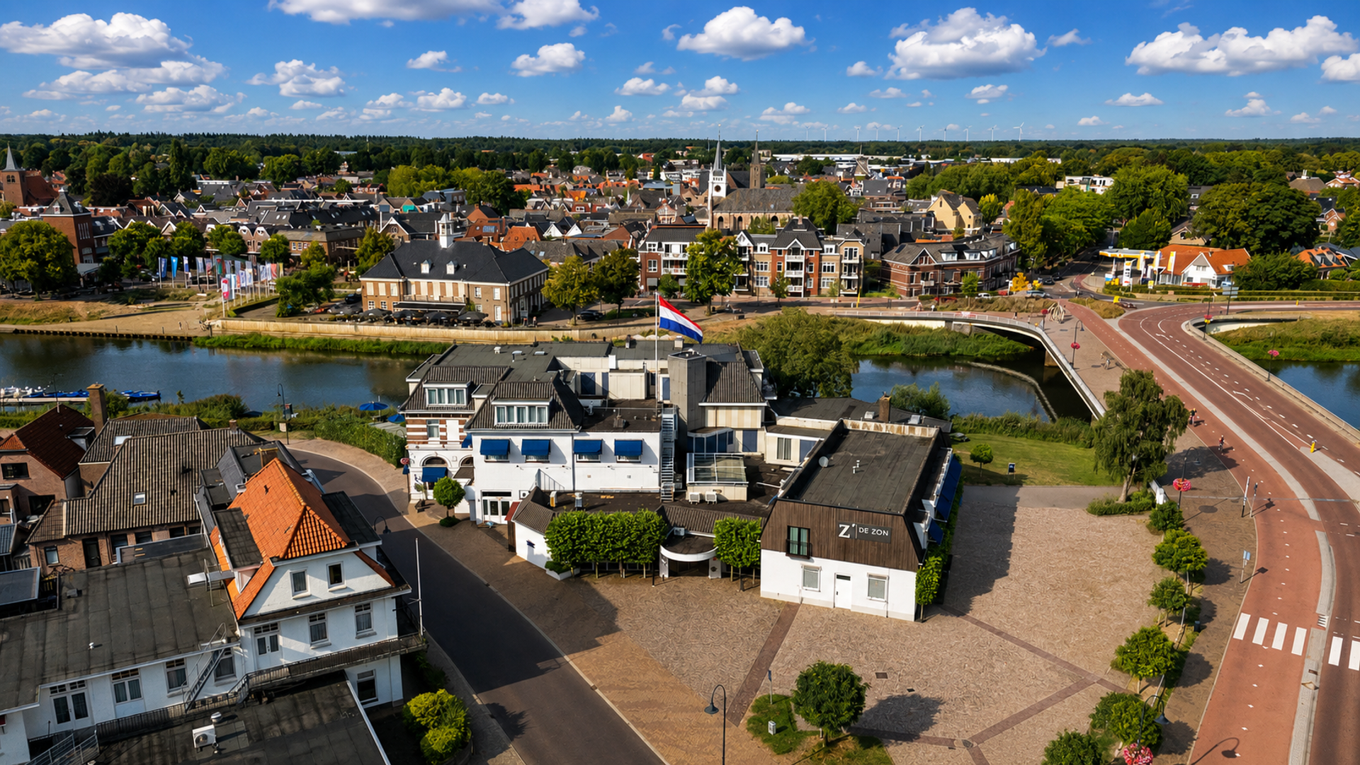 Luchtfoto van Hotel de Zon aan de Vecht met het centrum van Ommen op de achtergrond