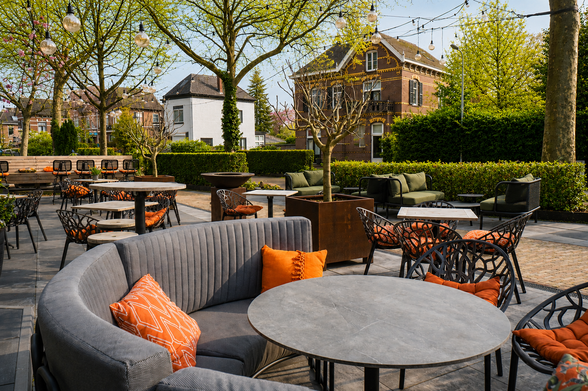 Sfeervol terras van Hotel Hof van Gelre in Lochem met loungezithoeken, sfeerverlichting en groen
