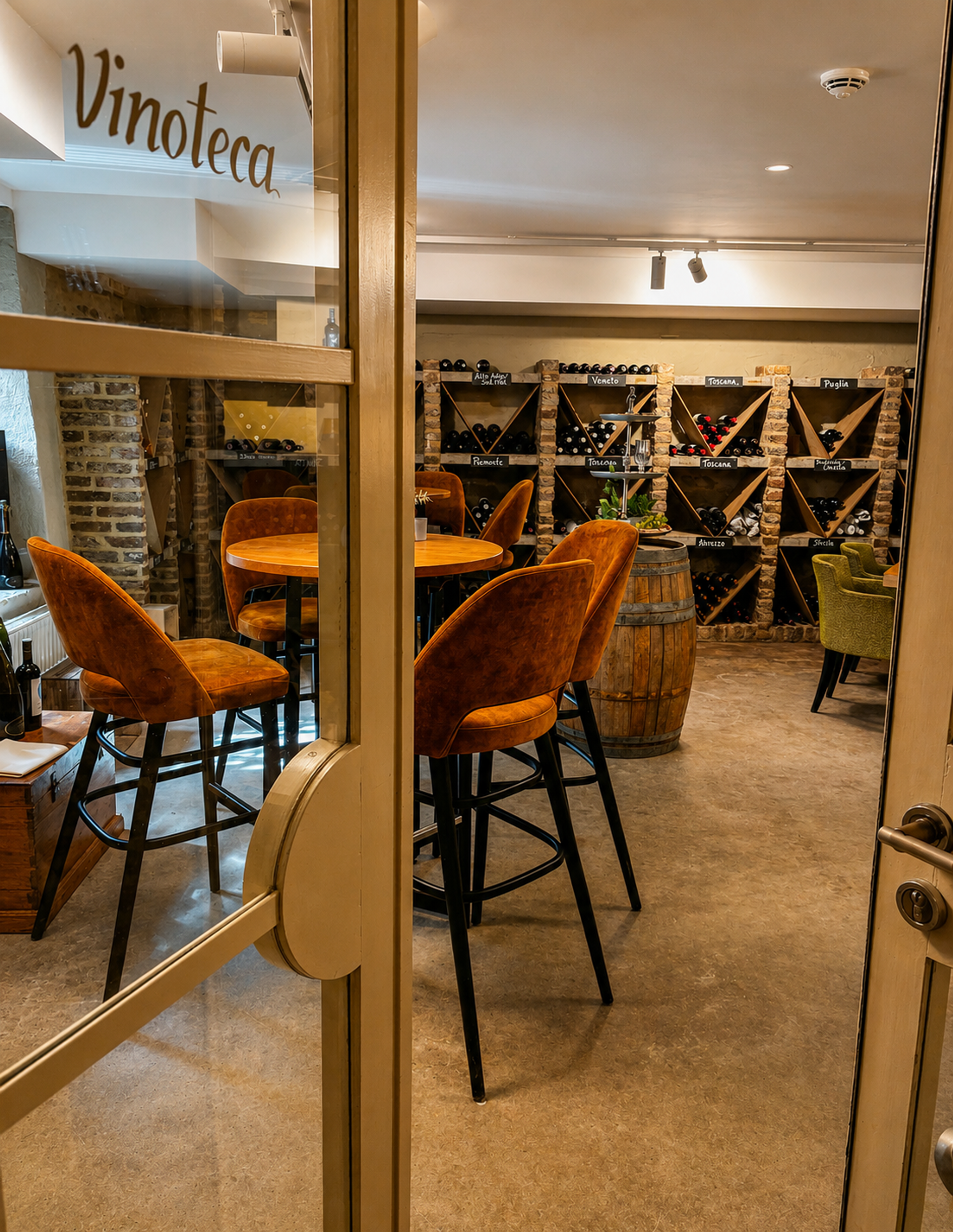 Vinoteca van Landgoed Winselerhof in Zuid-Limburg met Italiaanse wijnrekken, wijnvaten en sfeervolle barkrukken