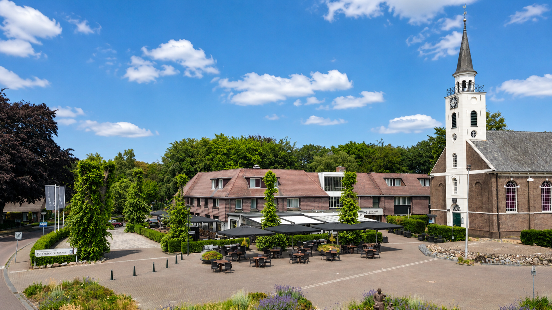 Hotel de Oringer Marke op het dorpsplein van Odoorn in Drenthe met terras en historische kerk
