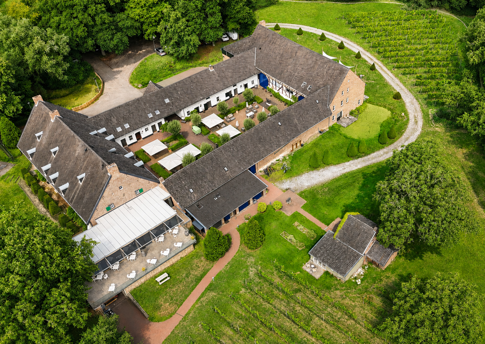 Luftaufnahme des Landgoed Winselerhof in Zuid-Limburg mit monumental Hotel, eigenem Weinberg und waldreicher Umgebung