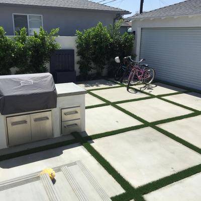 backyard with grill concrete blocks and astro turf grid