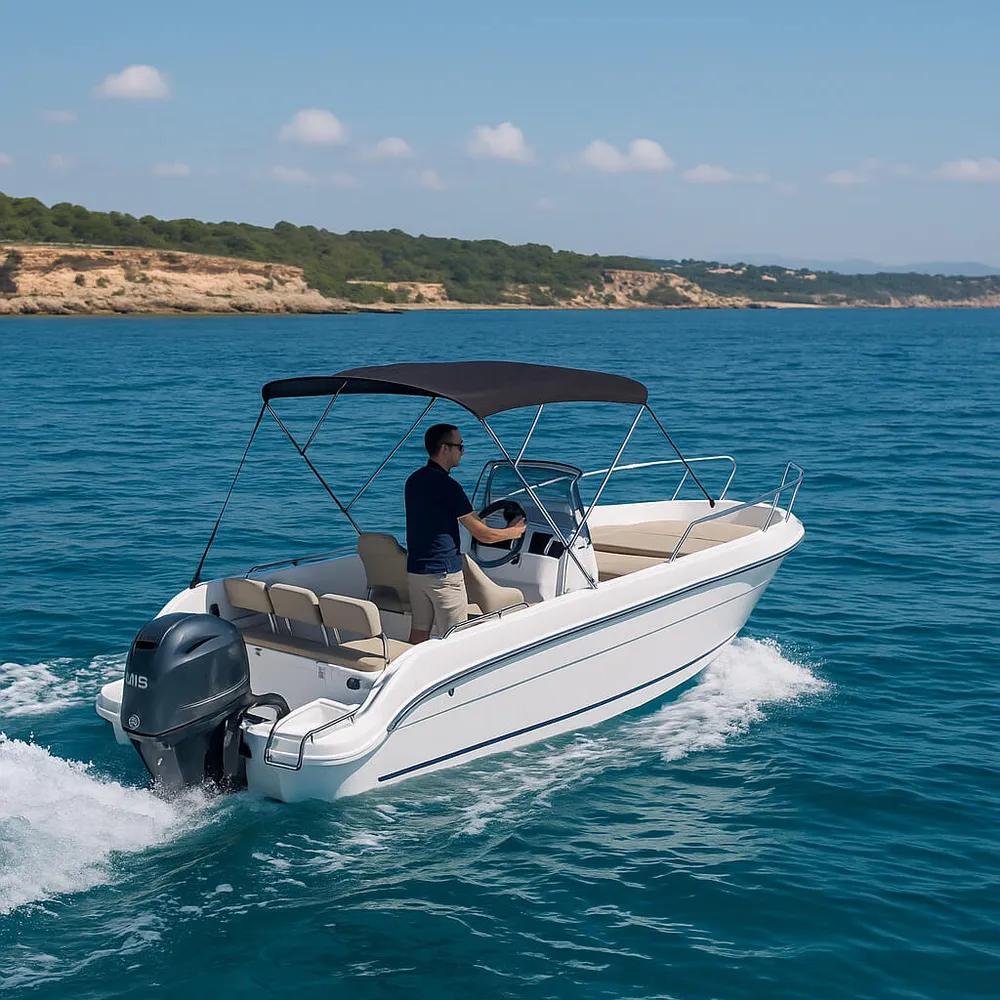 Patrón gobernando la barca navegando frente a la costa de Mallorca.