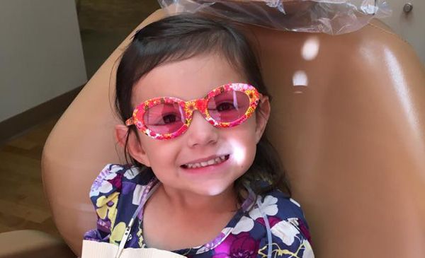 A little girl with pink colorful glasses on