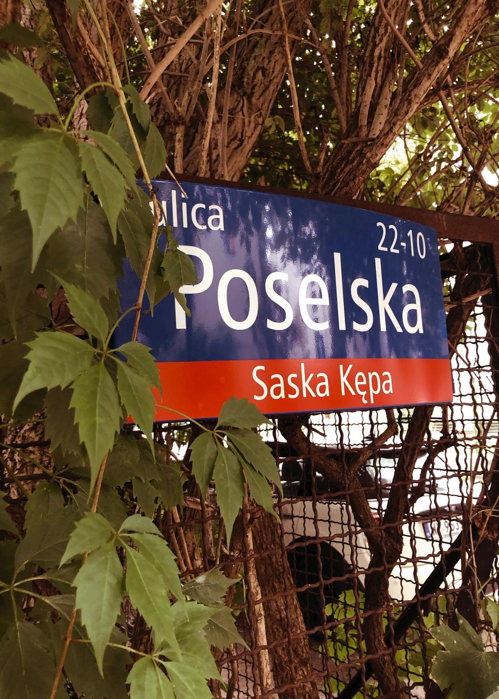 Tablica adresowa z napisem „ulica Poselska, Saska Kępa”